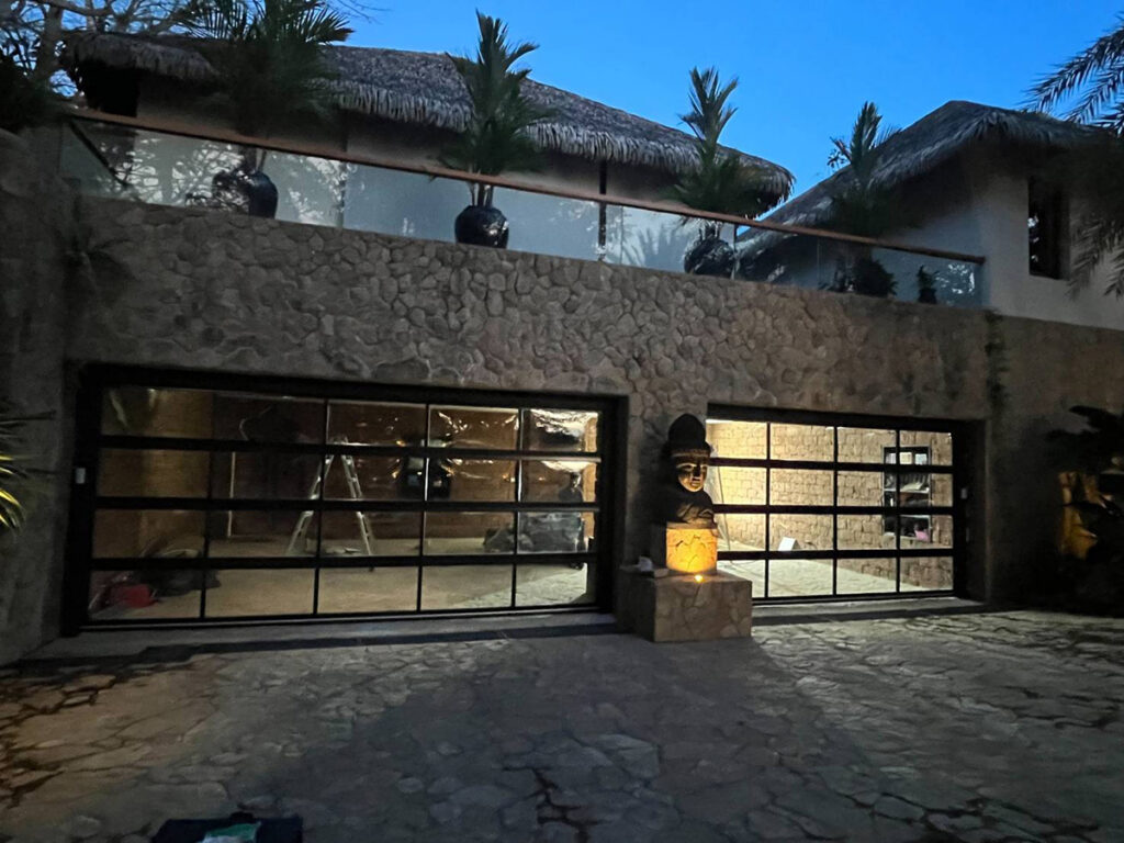 ประตูโรงรถกระจกเต็มบานติดตั้งตอนกลางคืนในประเทศไทย โดย OZ Door พร้อมมอเตอร์ SOMMER