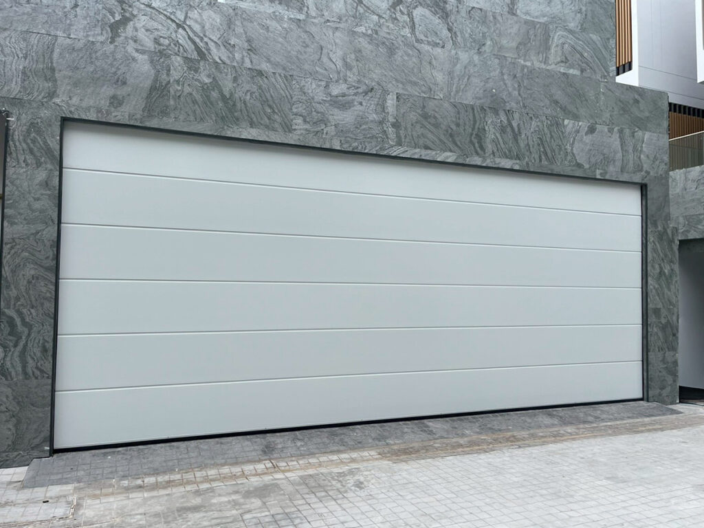 ดีไซน์แผงเรียบสีขาว สำหรับประตูโรงรถบานเซคชันมาตรฐาน โดย OZ Door Thailand