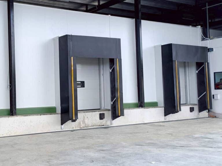 Sectional industrial door at a loading opening coordinated with dock sealing