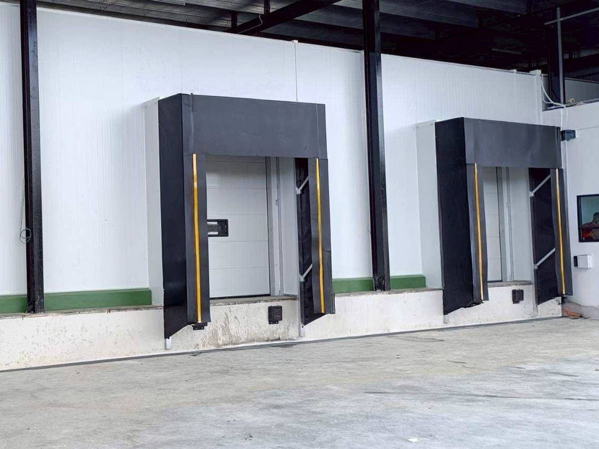 Sectional industrial door at a loading opening coordinated with dock sealing