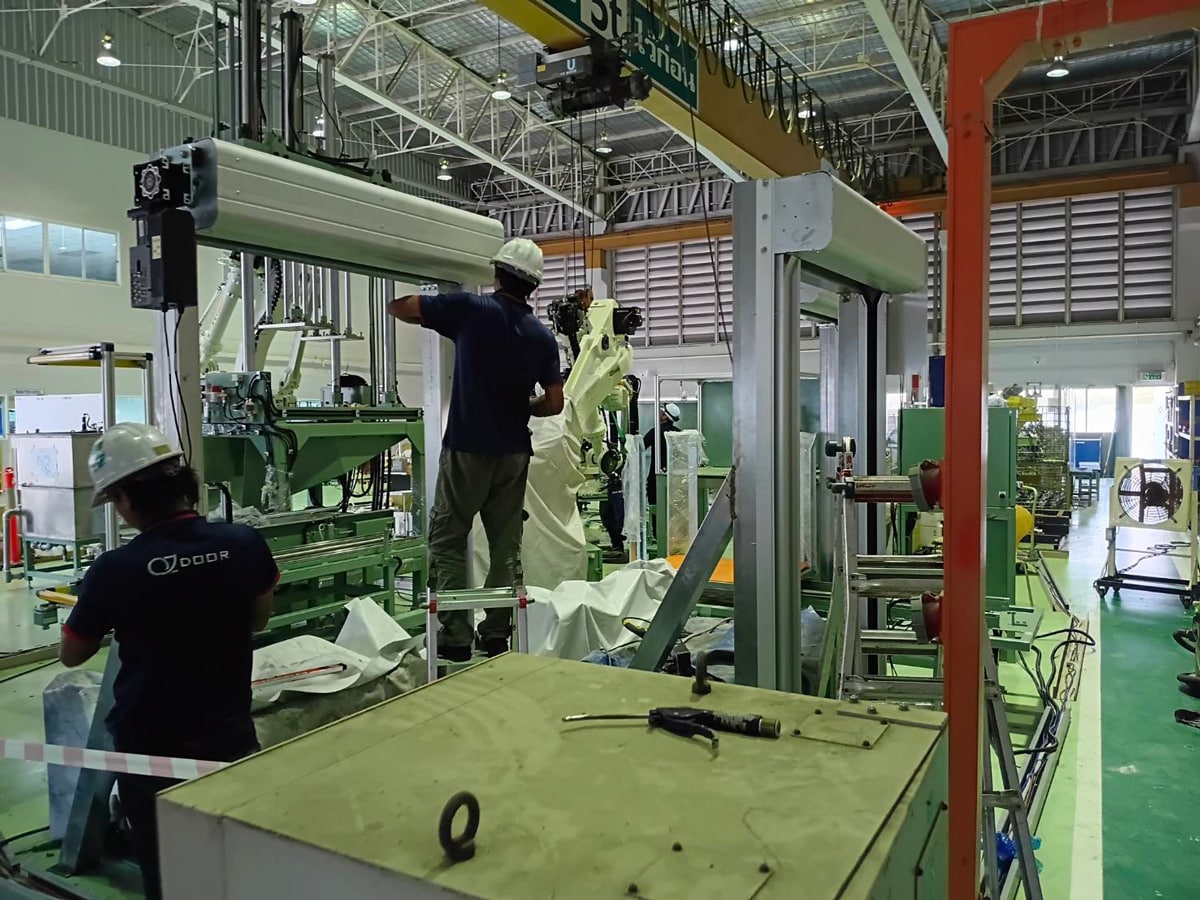 OZ Door team installing industrial door systems for factory and warehouse projects in Thailand
