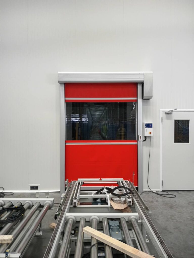 Red high-speed door beside a white personnel door
