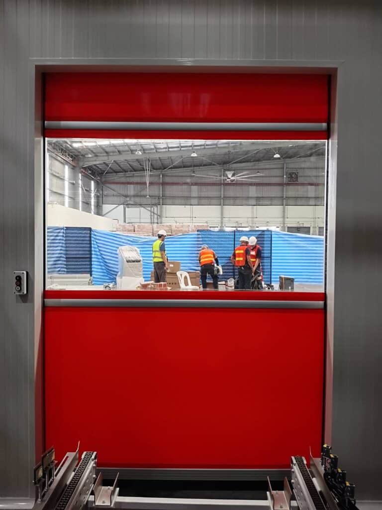 Red curtain with a vision panel above the roller conveyor