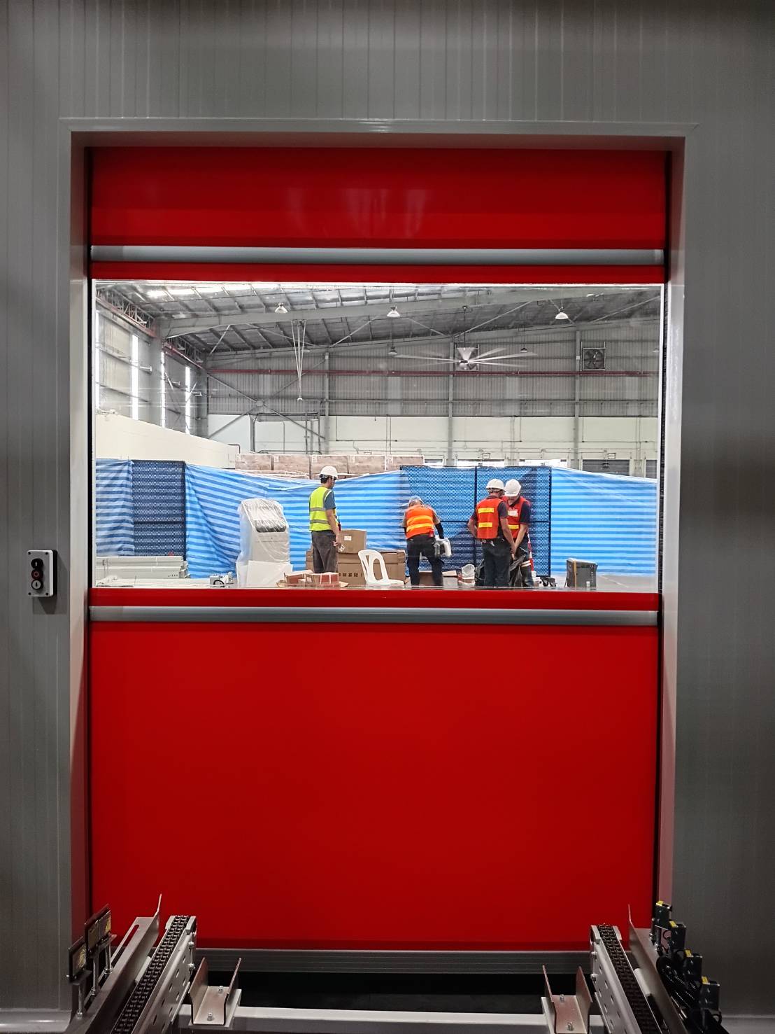 Red curtain with a vision panel above the roller conveyor