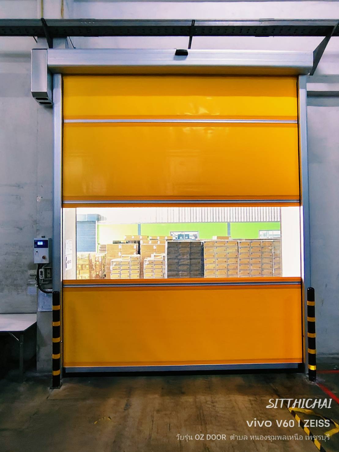 Yellow high-speed door with a clear strip at a warehouse opening