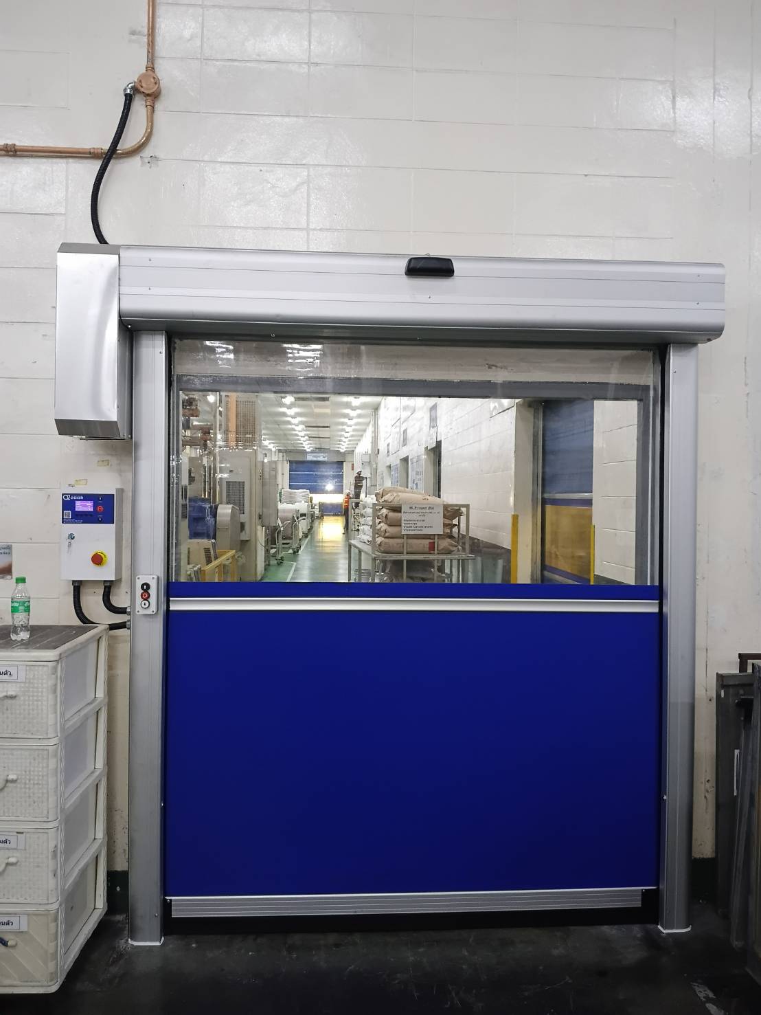 Small blue-curtain doorway with a clear section and wall-side control cabinet